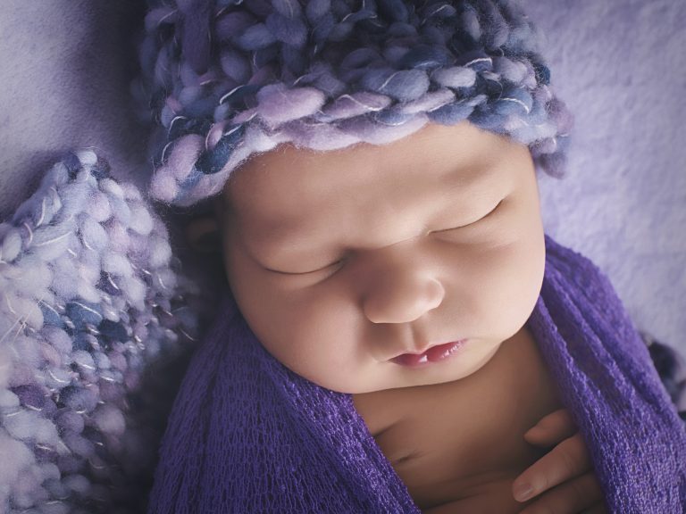 Baby in purple hat close up