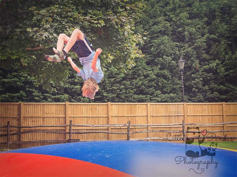 Boy doing backflips on bouncy castle