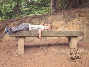 Little boy laying on bench