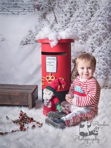 Little boy sitting by postbox