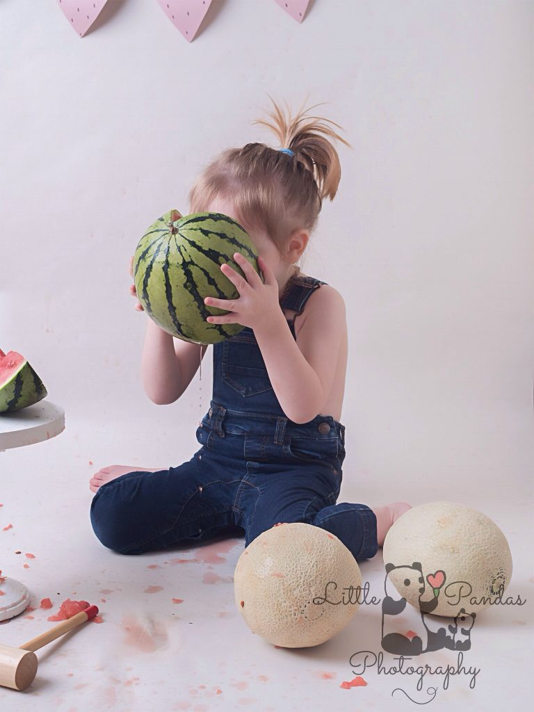Boy drinking juice out of melon