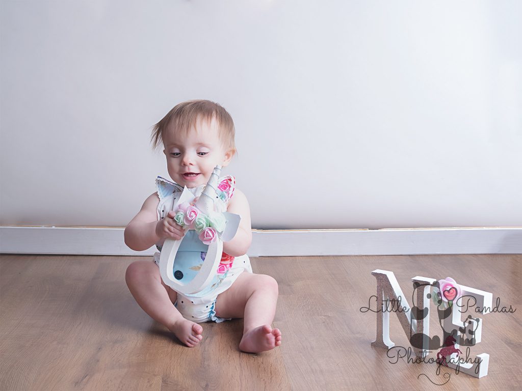 Little girl looking up pre cake smash
