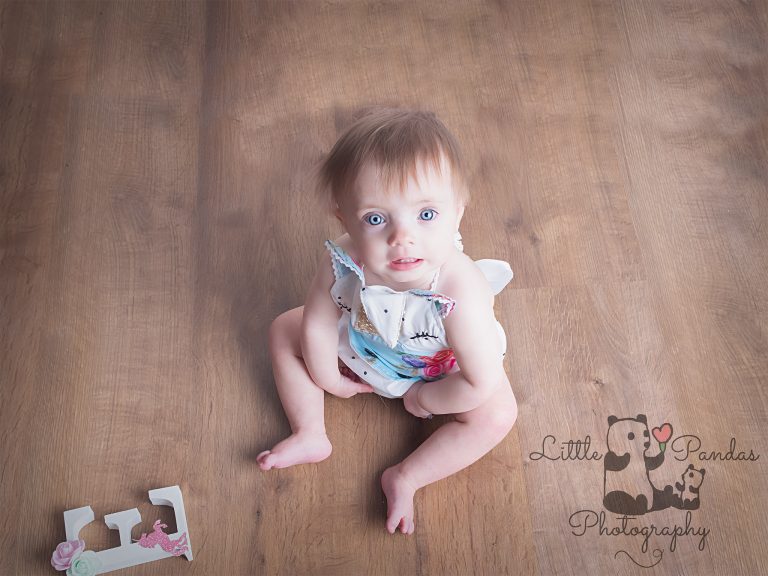 Little girl in unicorn romper looking up