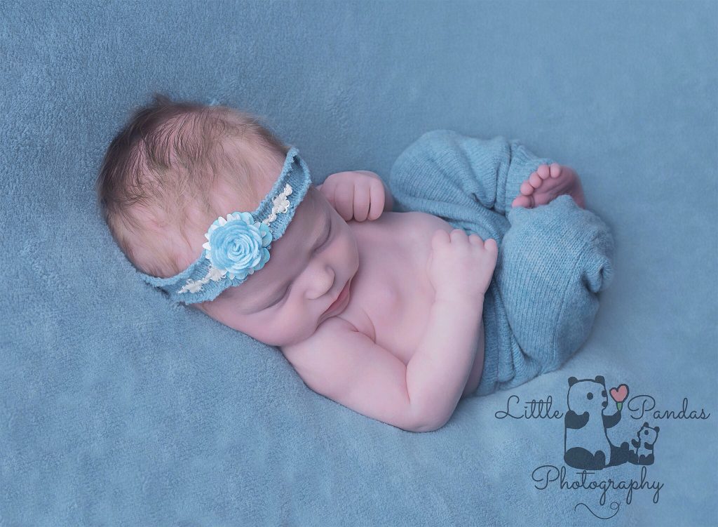 Baby girl in aqua asleep on back